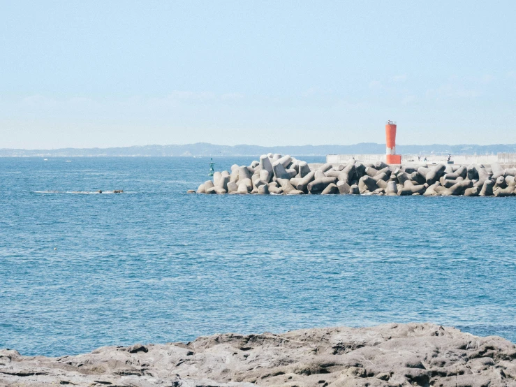 the lighthouse is out on the side of the water