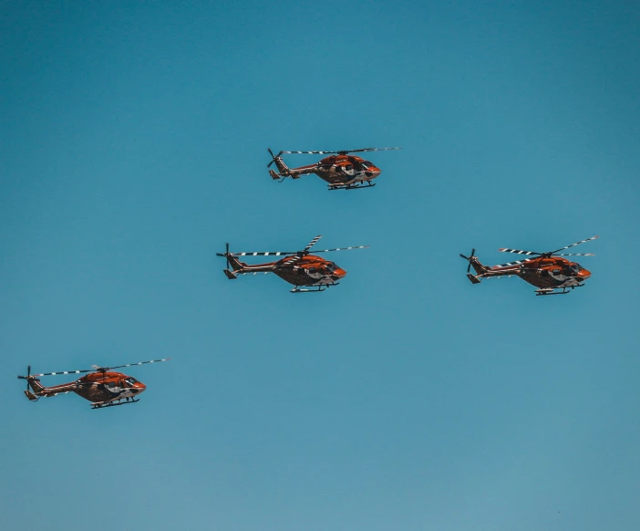 a group of helicopters flying through the sky