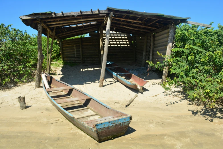 there is an old wooden row boat in the sand