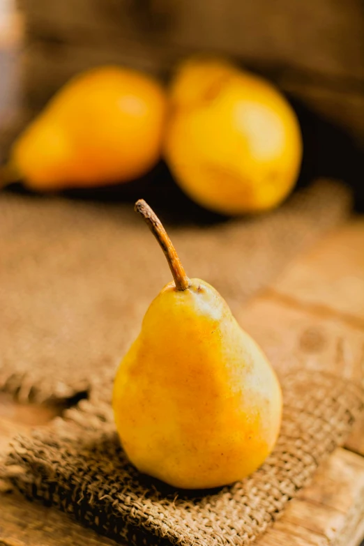 pear sitting on burlap cloth in front of other fruit