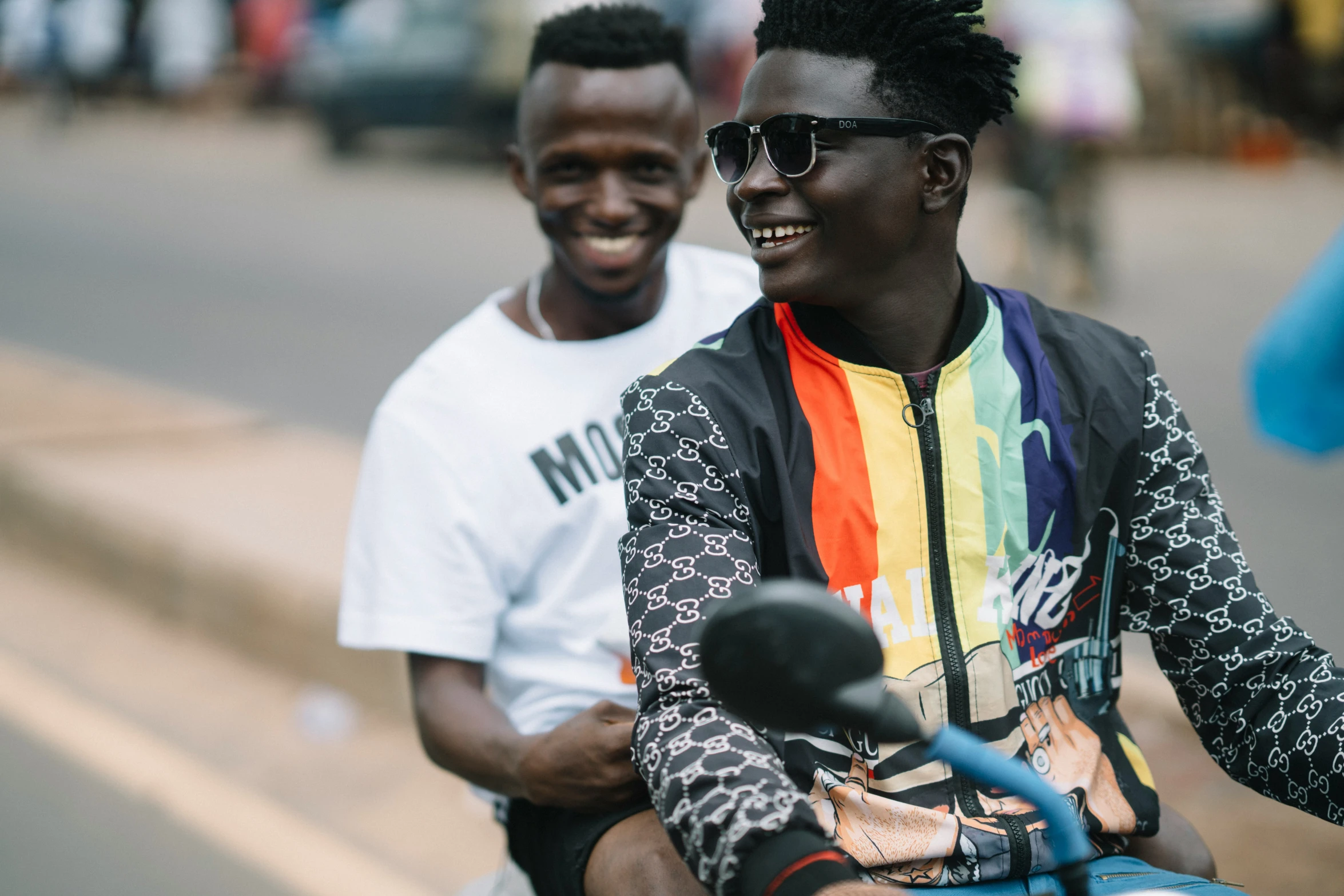 a pair of men ride a blue motorcycle