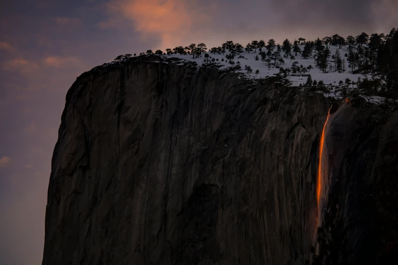 a waterfall is in the middle of a snowy hill