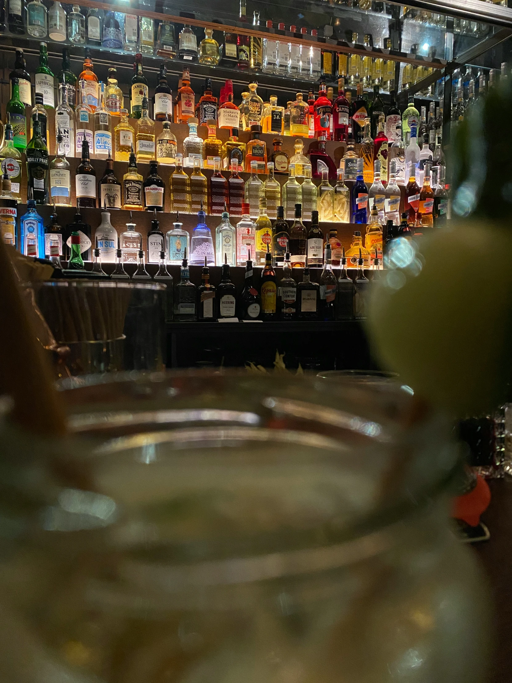 close up of bottles and glasses on bar top