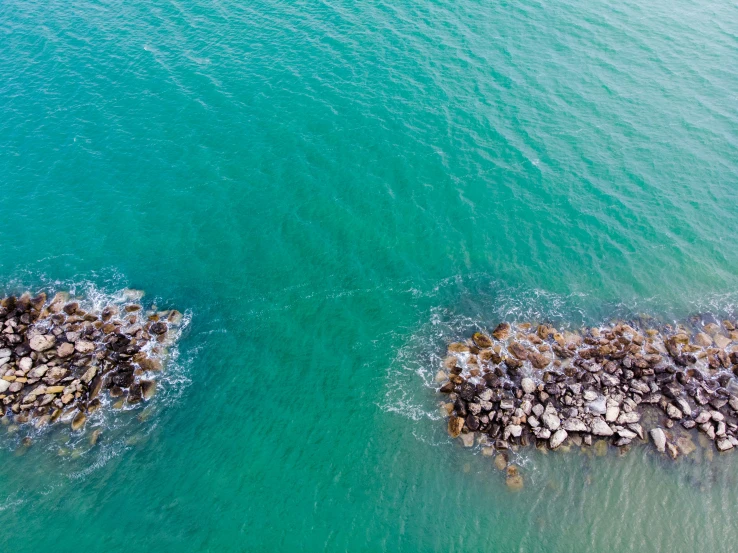 water and a large rock island in a blue ocean