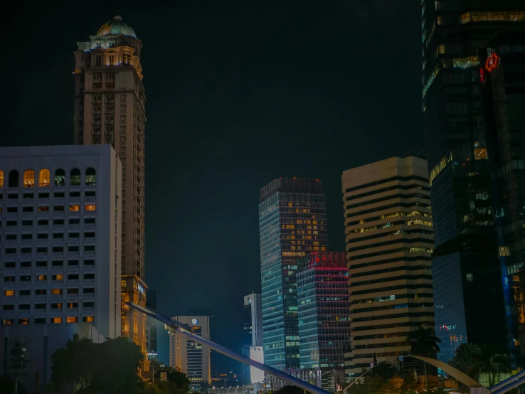 the city is lit up at night with many tall buildings