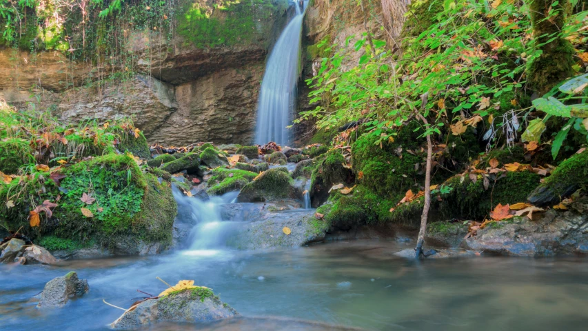 the small waterfall is flowing over rocks