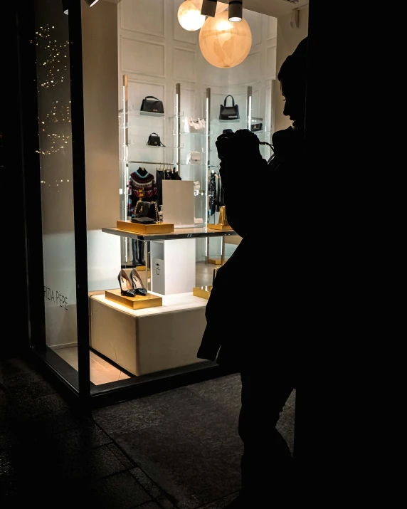 two people standing near the window of a store