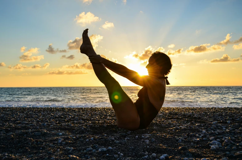 the woman is practicing yoga on the beach