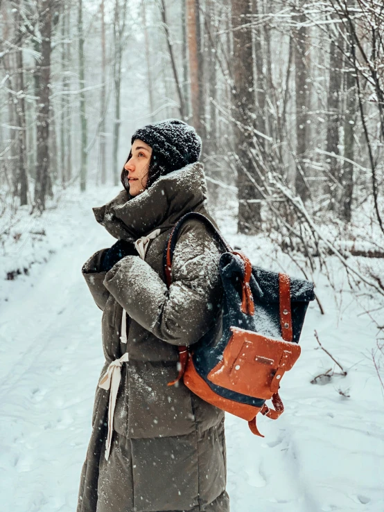 a woman in the snow carrying a small bag