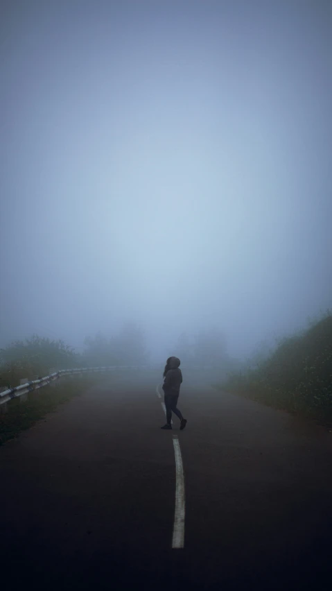 a lone person walking alone on a foggy street