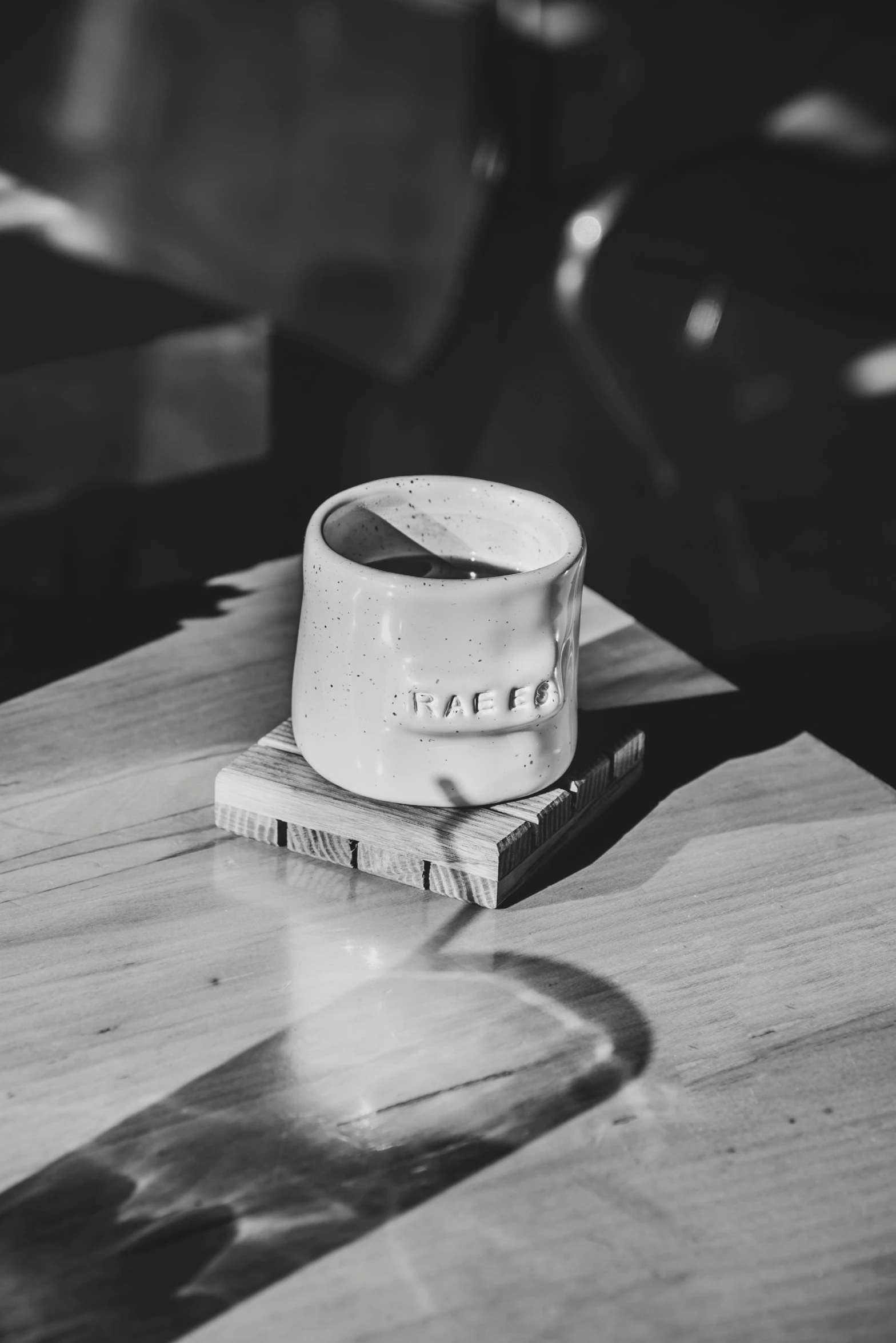 a small wooden table with a white cup