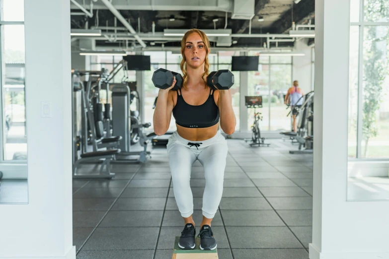 a woman doing a box jump in a gym