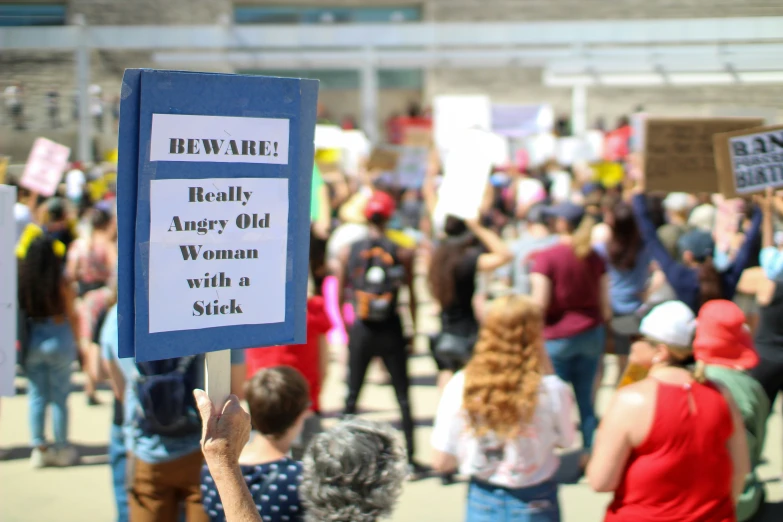 a crowd of people on a city street holding signs