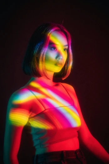 a woman is posing with a multicolored background