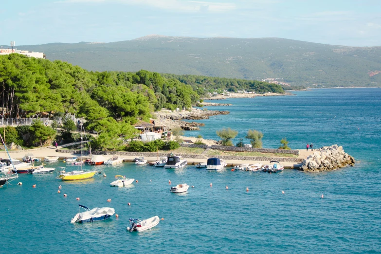 boats anchored near the shore of a small beach