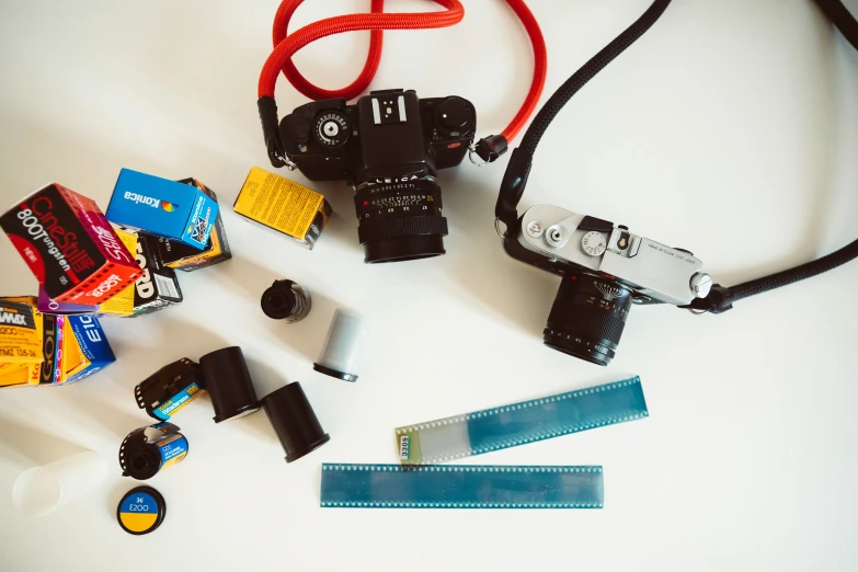 a group of camera and other items sitting on top of a white surface