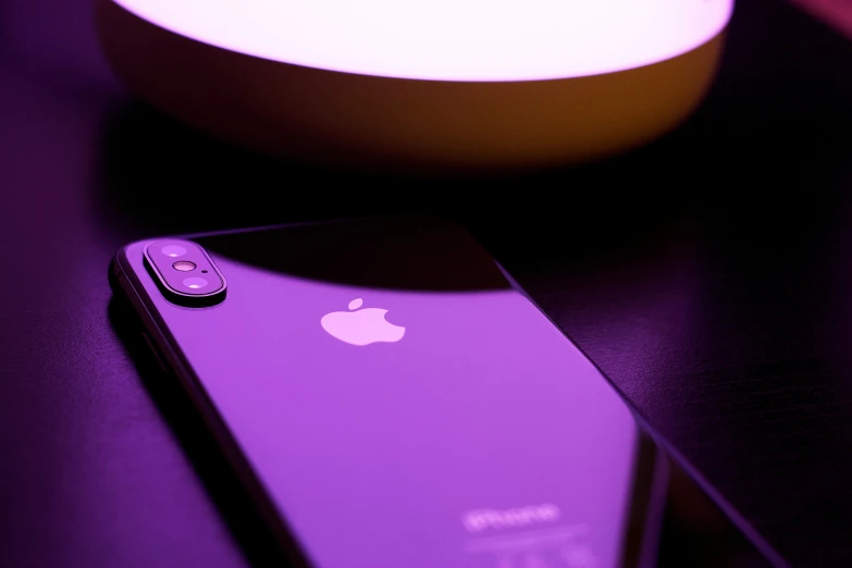 the iphone is sitting on a purple table