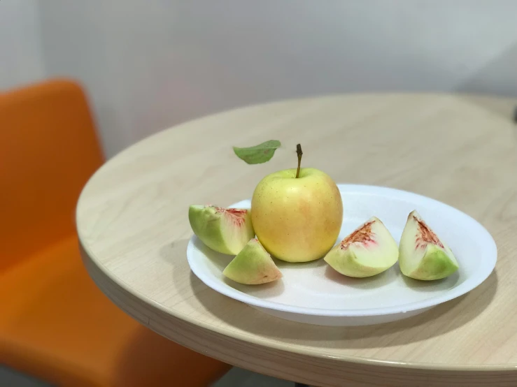 the plate has a green and red fruit on it