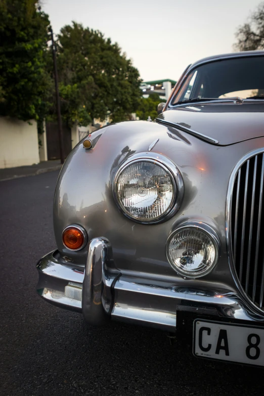 a vintage style silver car parked in the street