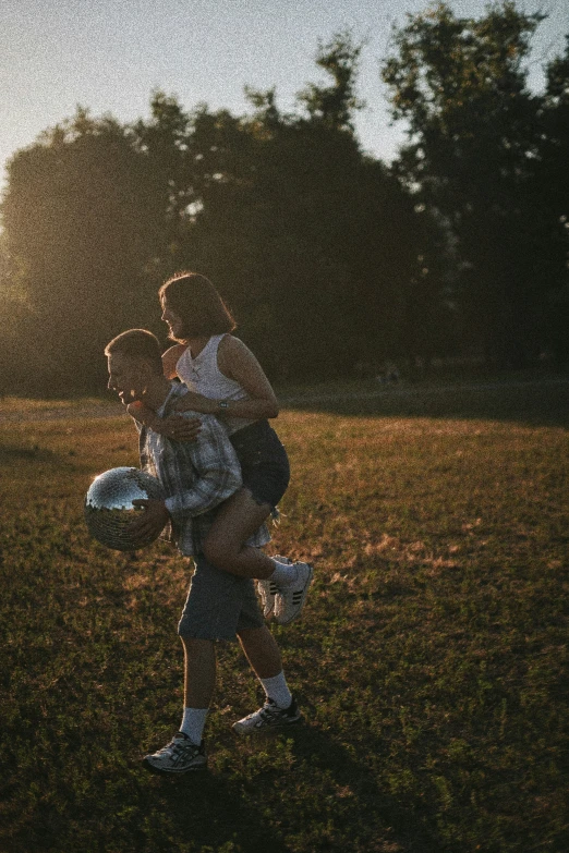 two people play with a ball in a grassy field