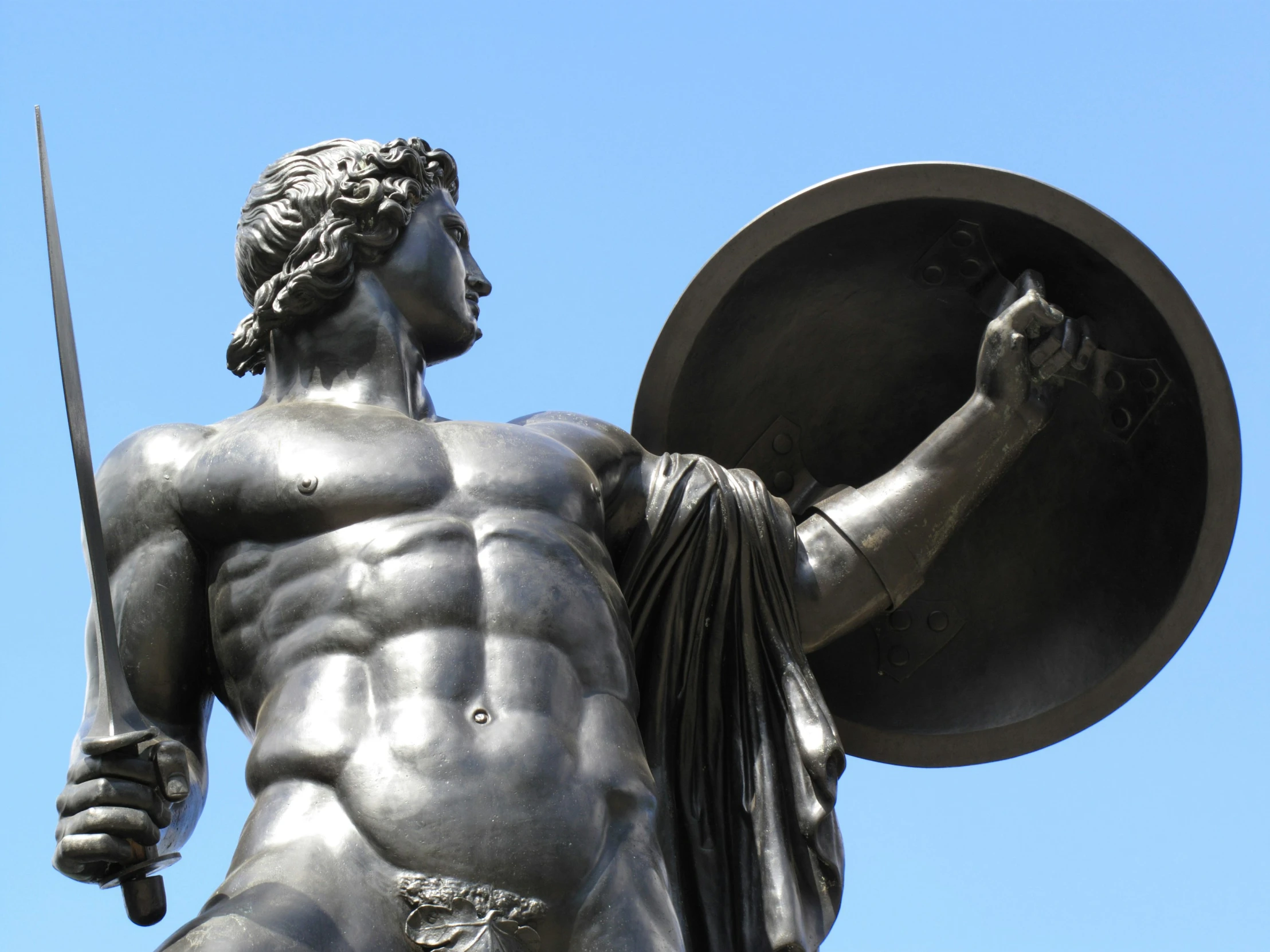 the statue of atlas is holding an sword and shield