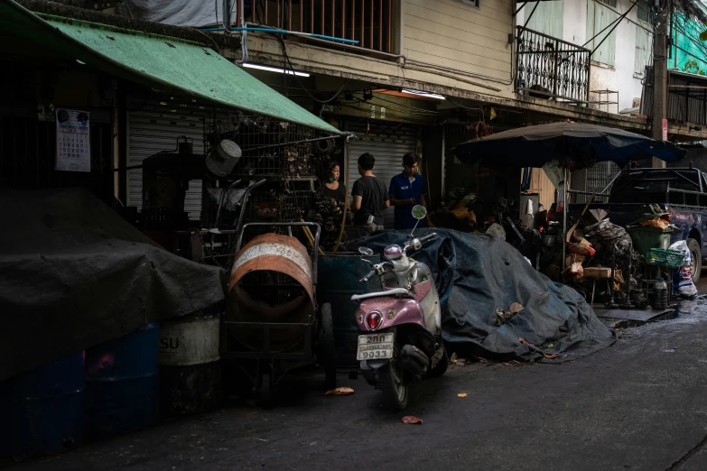 an old street with junk piled over and parked scooters