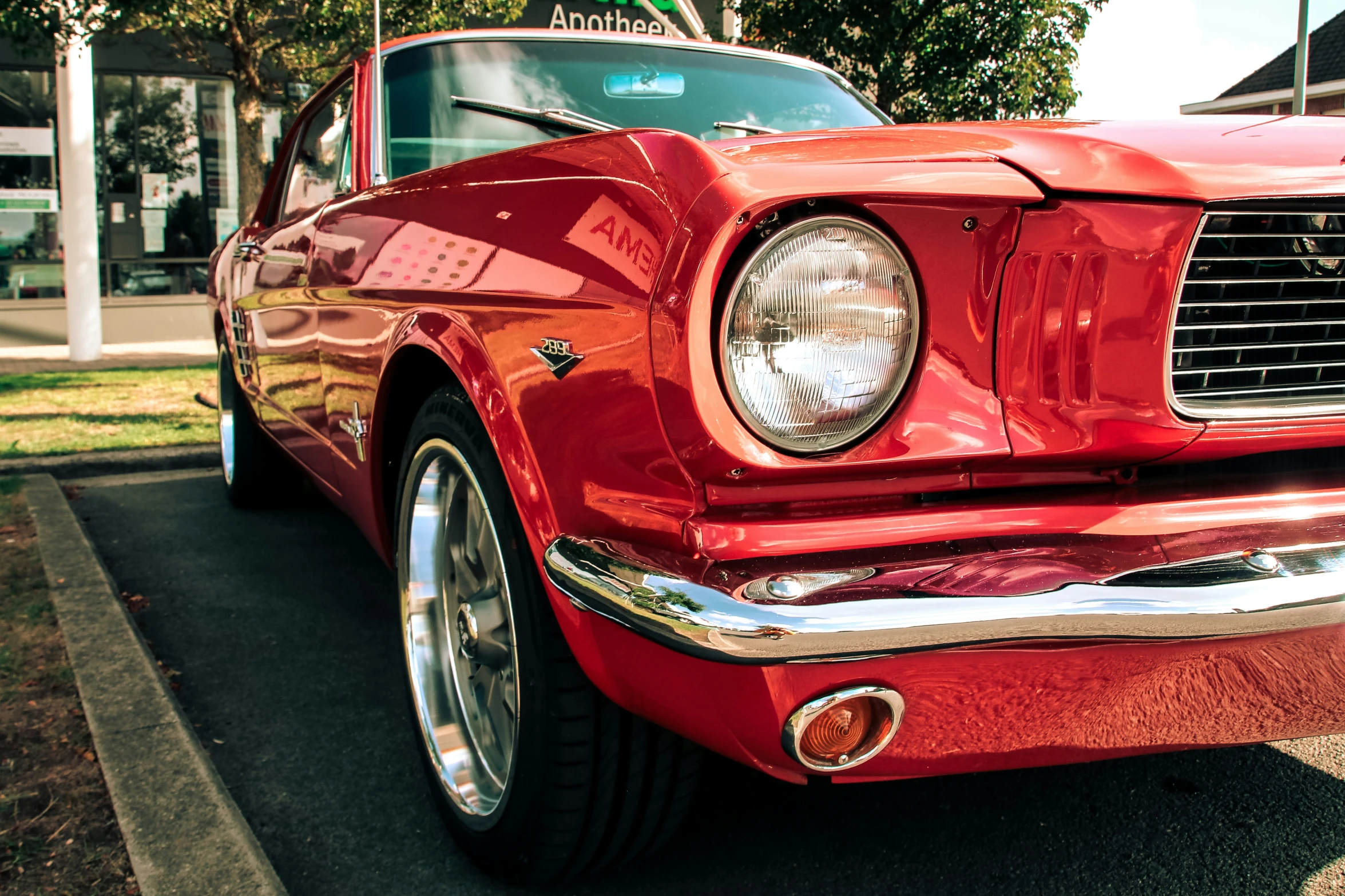 a classic muscle car on the road, front bumper and side view of it