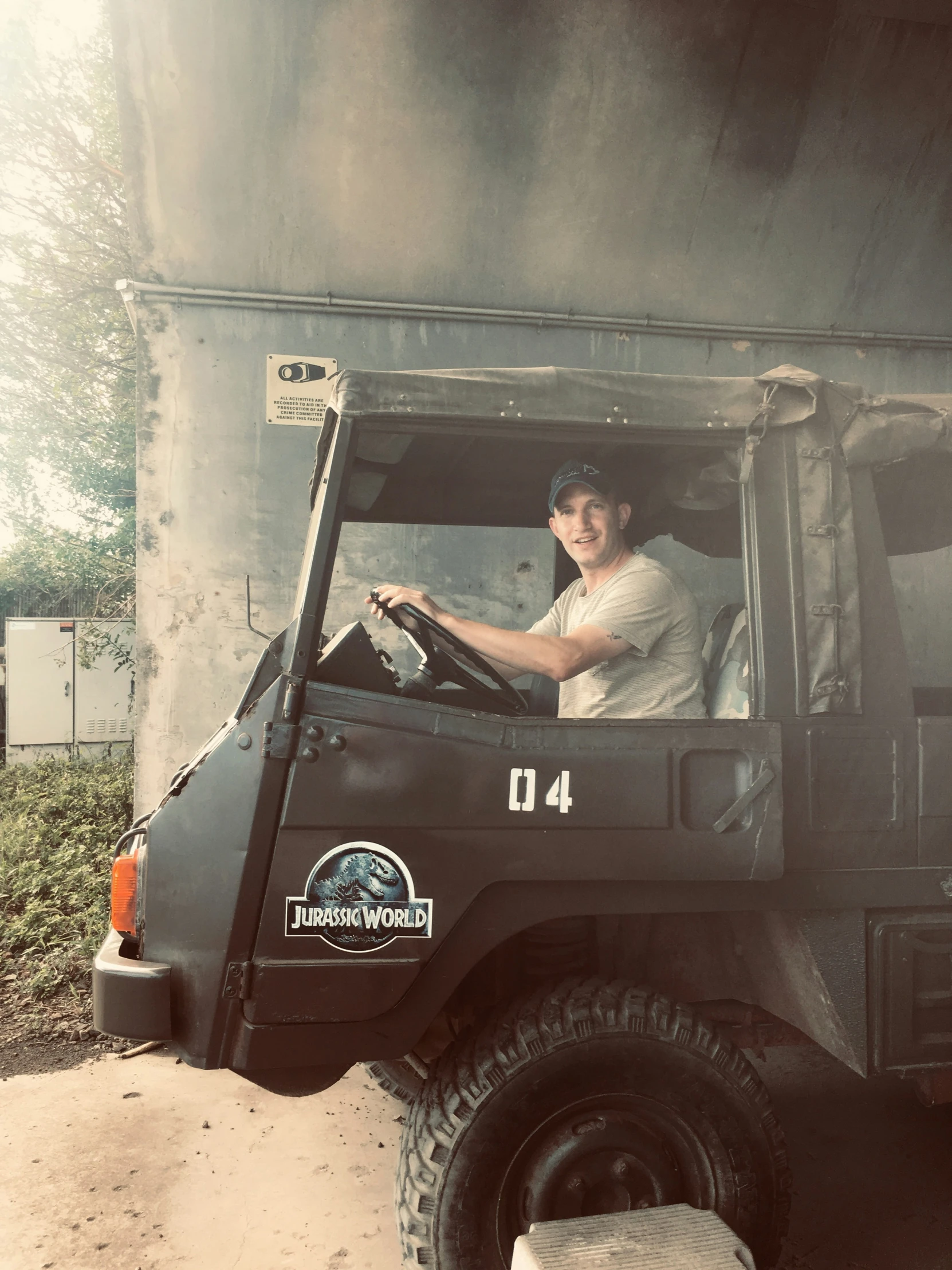 a man driving a black truck down a dirt road