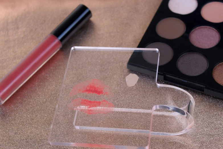 a close up of lipstick and makeup in a glass container