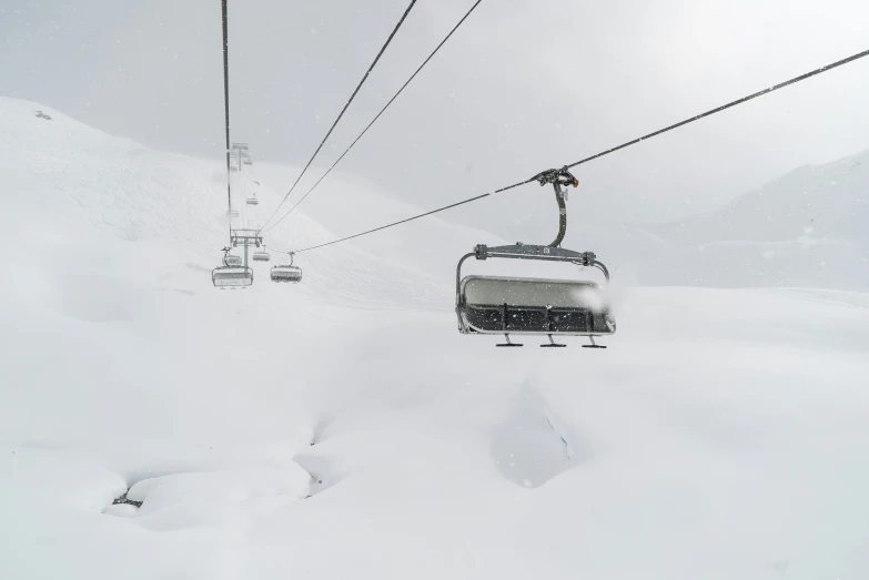 a ski lift going over a snowy mountain with skis