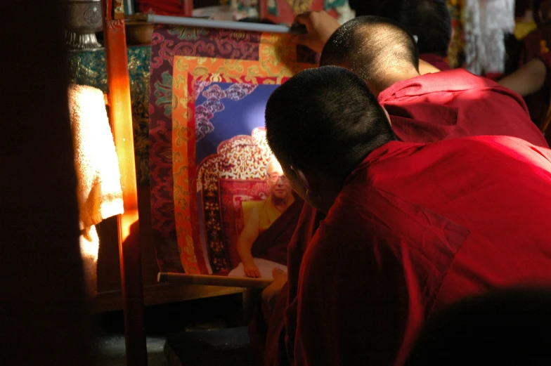 two people who are kneeling and looking at some artwork