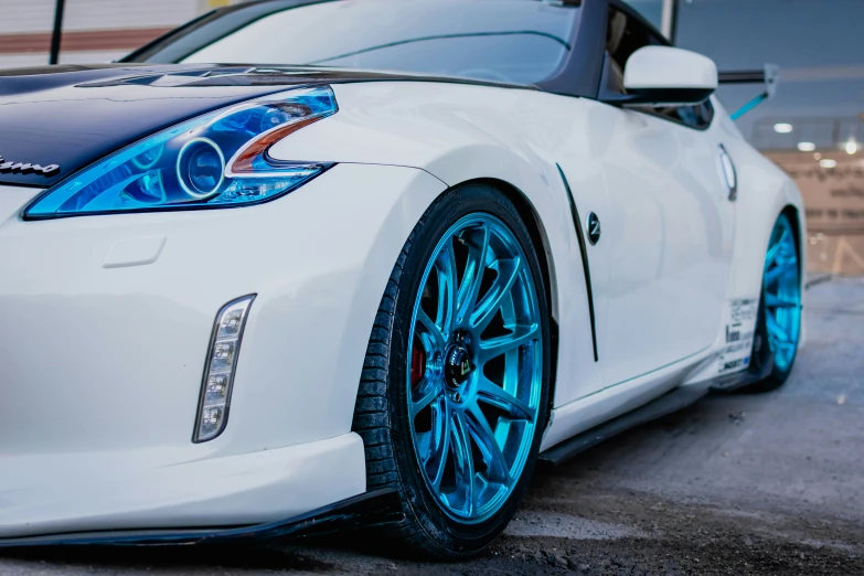 a white nissan sports car parked on the side of the street