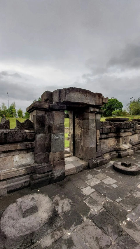 several ancient stone buildings near a green grassy field