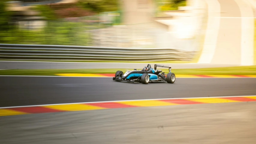a blue race car is rounding a curve