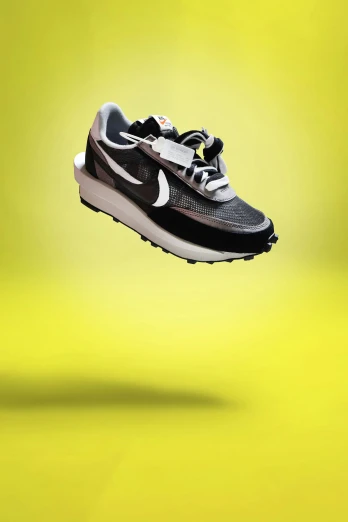 a black nike running shoe in mid - air against a yellow background