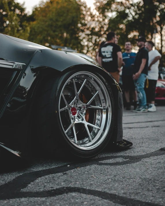 some people standing by the side of a car on a road