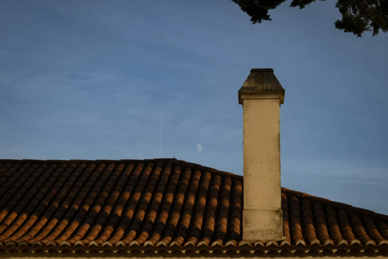 a clock tower against the blue sky with tiled roofs