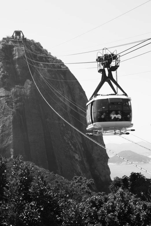 a cable car sitting on top of a mountain next to a forest