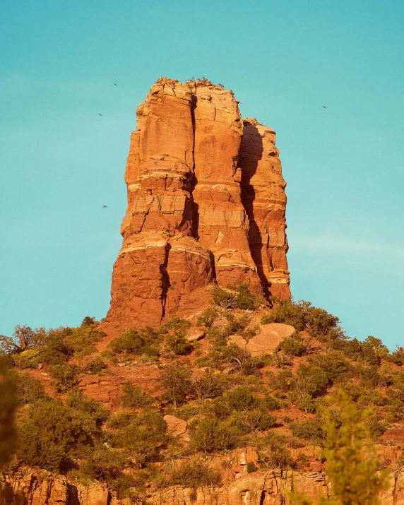 a very tall stone mountain sitting on top of a hill