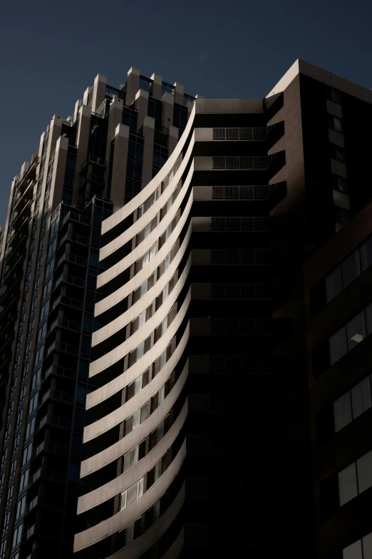 a tall building with a curved corner and the windows closed