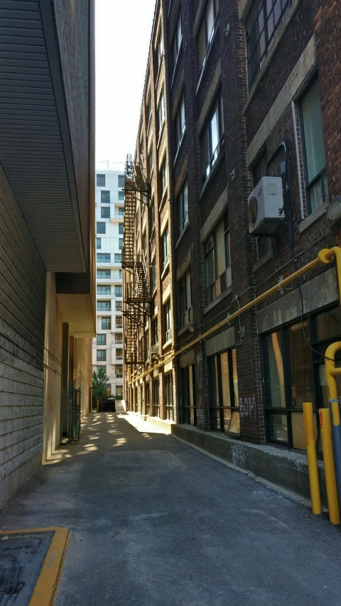 an empty road through two buildings near a building