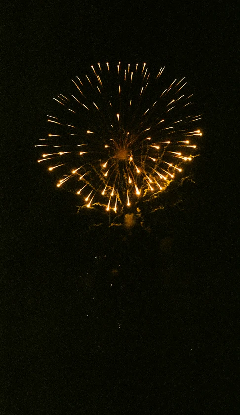 a firework in the sky with a large yellow star