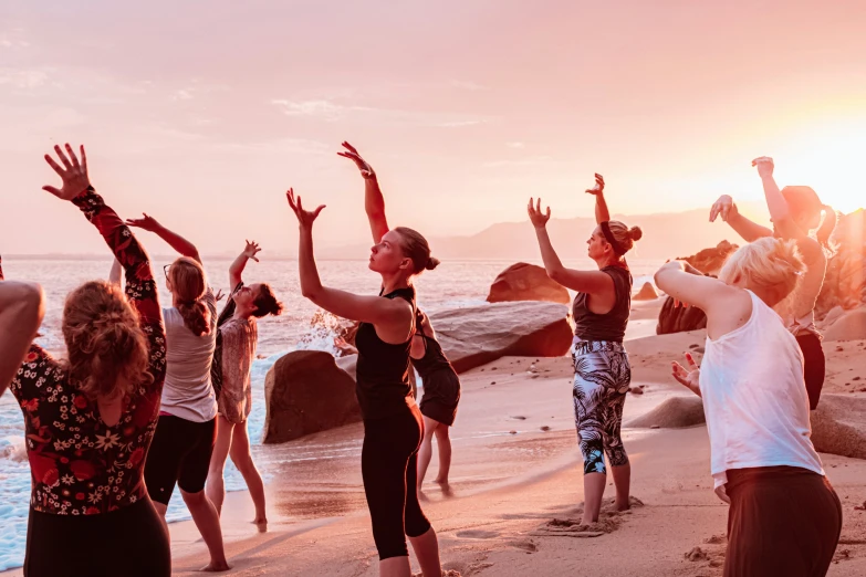 a group of people stretching on the beach