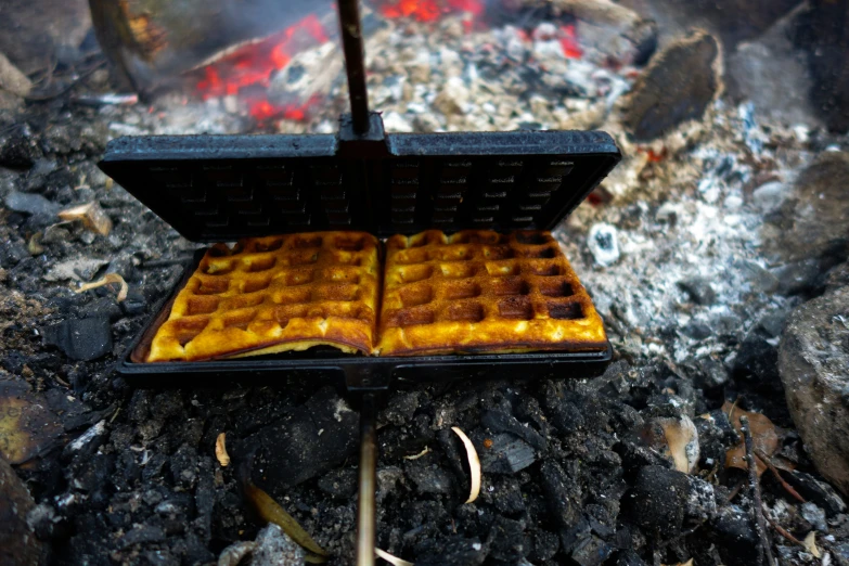 a waffle iron sitting on the ground covered in bananas