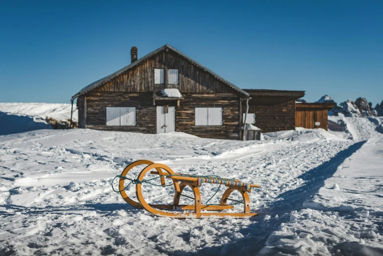 an old sled sits in the snow on the edge of a ski resort