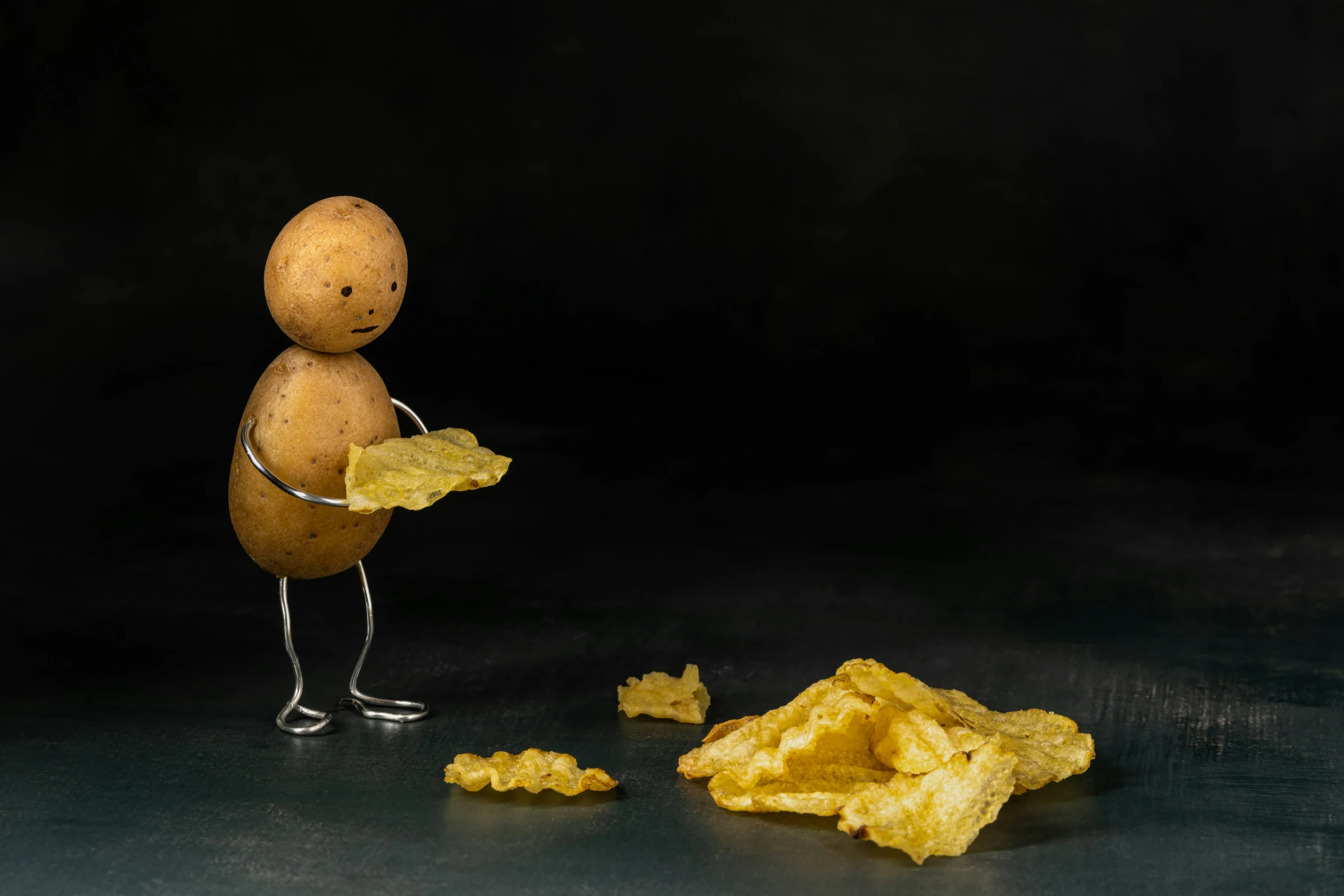 a doll holding up a piece of potato chips in front of it