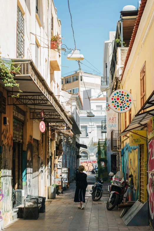 an empty alley way with parked motorcycles and stores