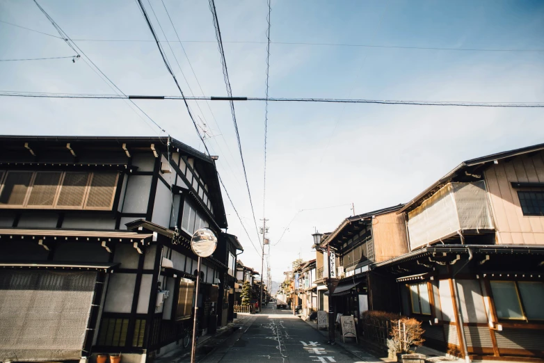 a street is lined with buildings and power lines