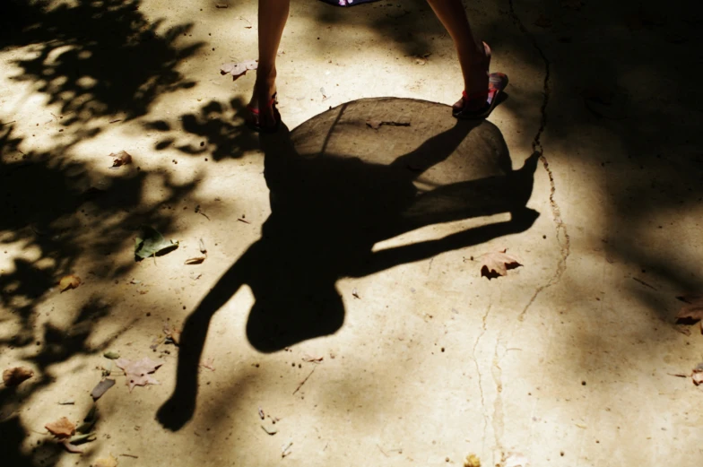 shadow of woman riding a skateboard on concrete ground
