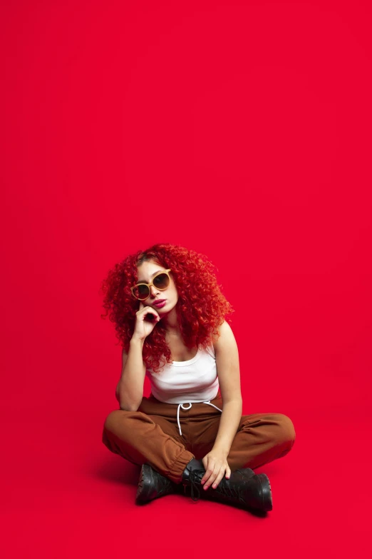 a woman is sitting on the floor with red hair